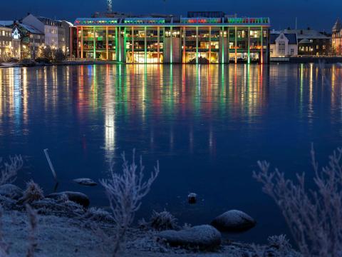 Ráðhúsið lýst með jólaljósum og frost yfir Tjörninni.