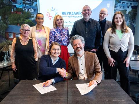 Drífa Snædal, spokesperson for Stígamót, and Mayor Dagur B. Eggertsson shake hands on the contract. Joining them are representatives from Reykjavík City's Welfare Council. 
