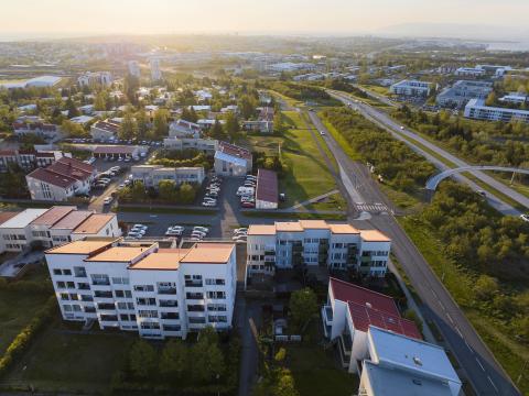 Aerial view of Breiðholt, with the city and sunset in the background