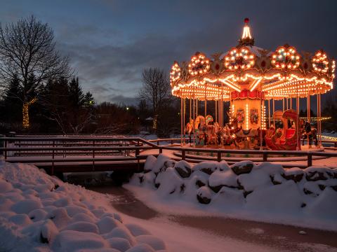 Lit carousel in Ljósadalur in Laugardalur, darkness and snow.