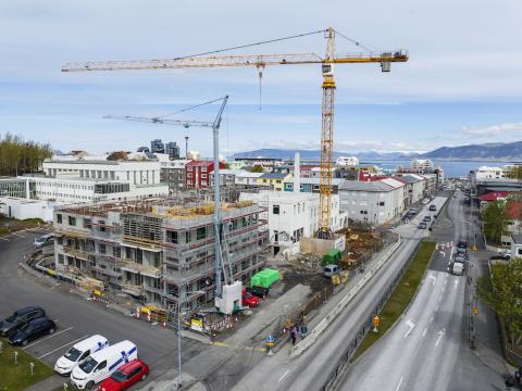Overview of streets and buildings under construction. Large construction crane over a building.