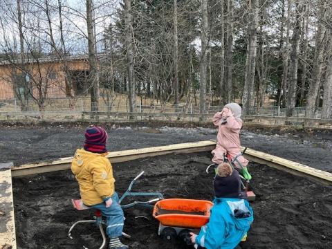 Börn að leik í sandkassa.