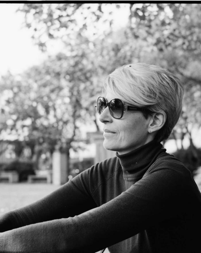 Woman with sunglasses sitting outdoors in nature.