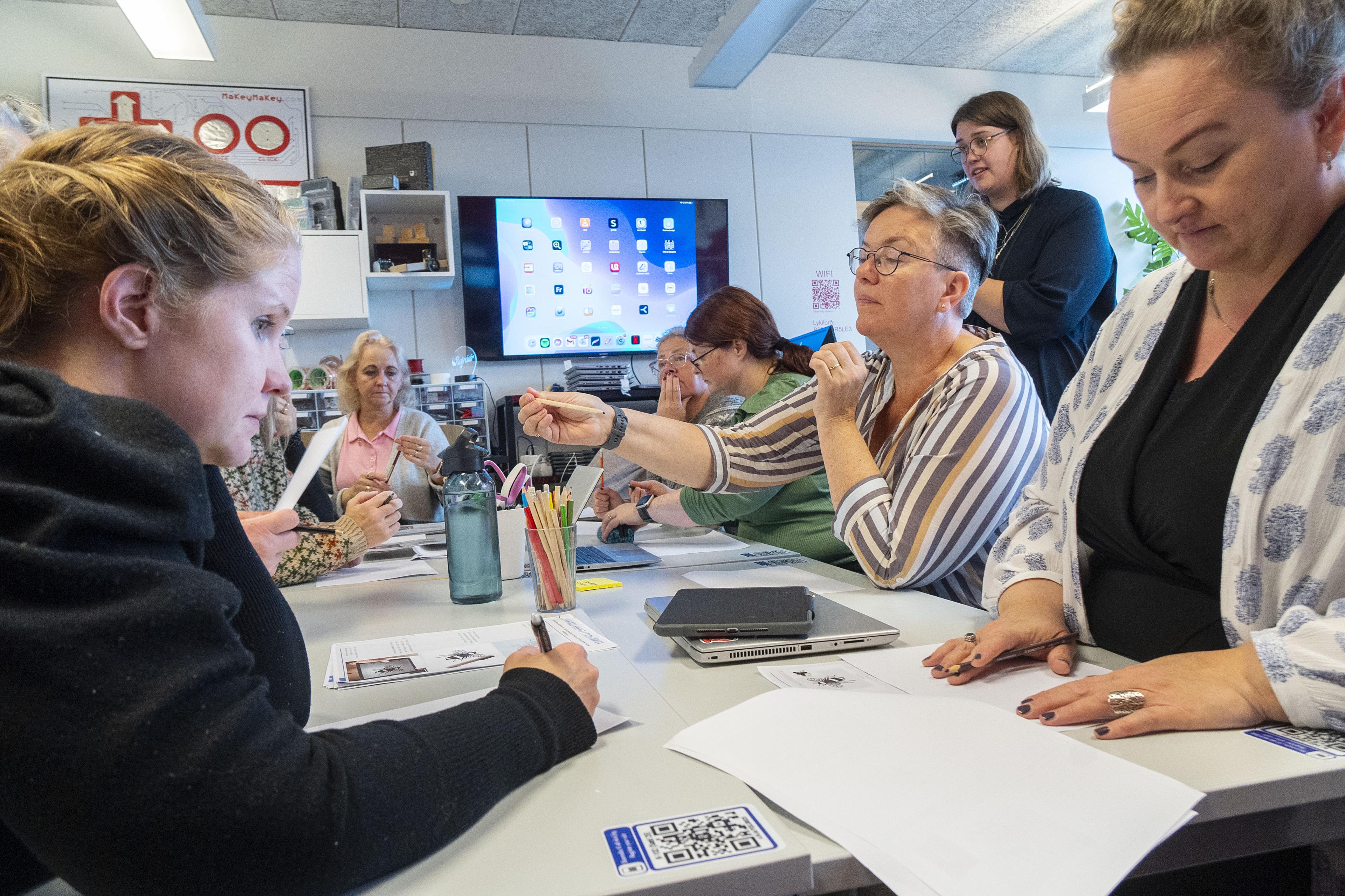 Kennarar sitja við borð í sumarsmiðju skóla- og frístundasviðs