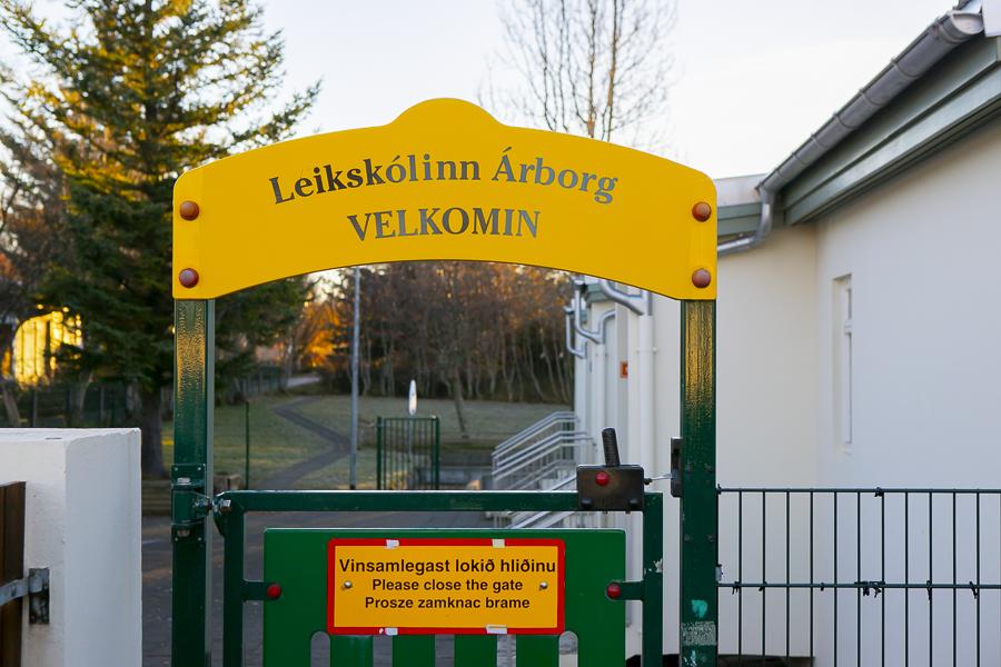Hlið að leikskólanum Árborg. Yfir hliðinu stendur á gulu skilti: Leikskólinn Árborg, Velkomin
