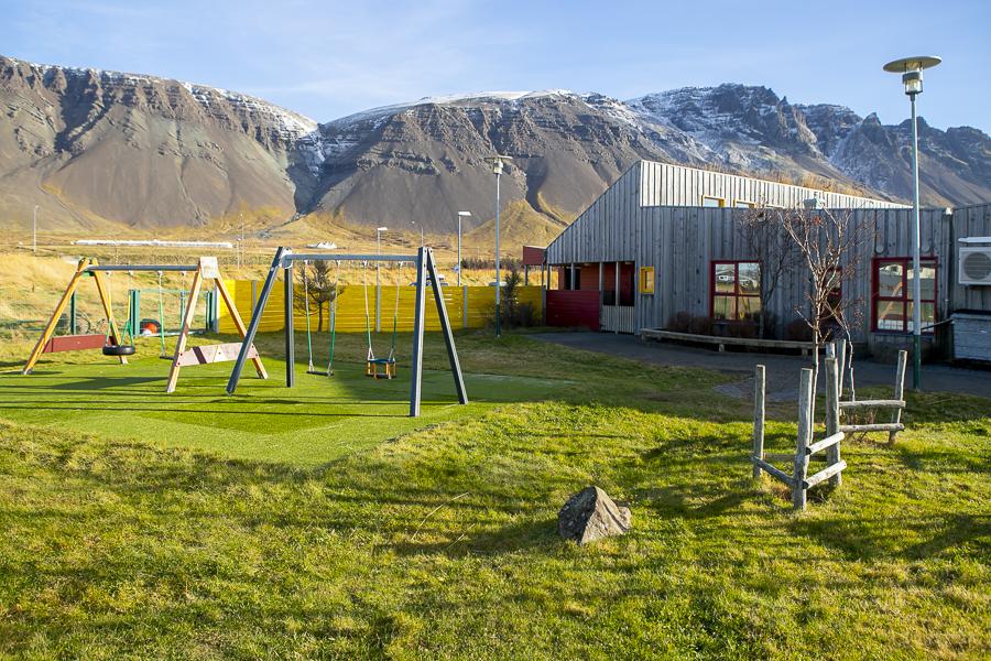 Leikskólinn Berg og leiktæki á lóðinni.