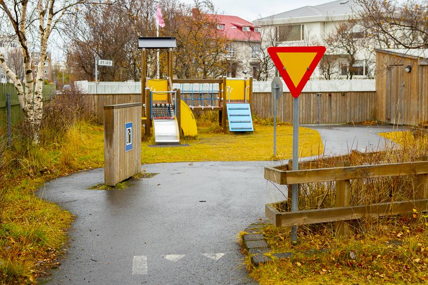 Umferðarskilti, leikbensínstöð og rennibrautir á útileiksvæði leikskólans Hlíðar, Eskihlíð