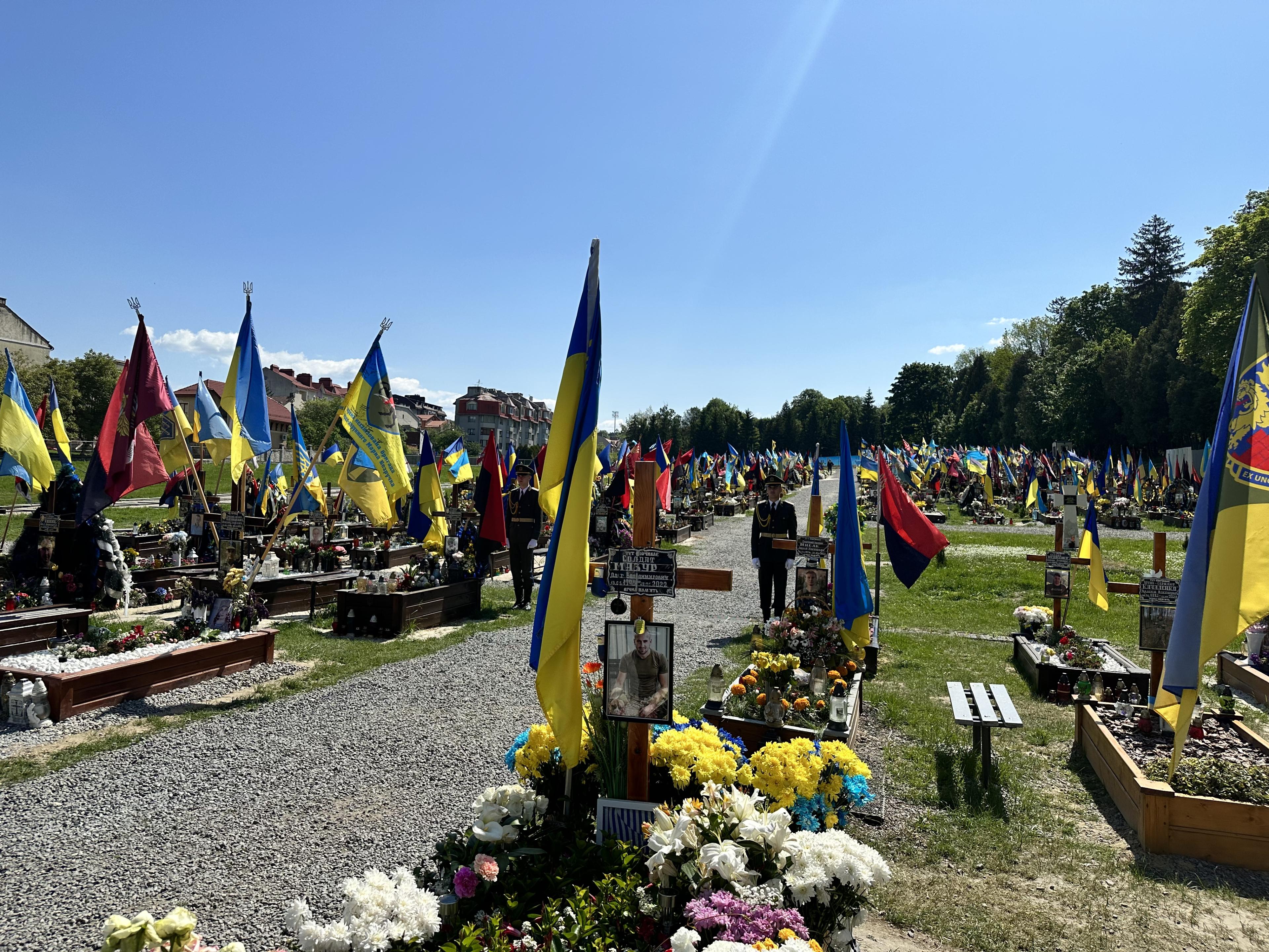 Hermaður stendur vörð í kirkjugarði fyrir hermenn í Lviv