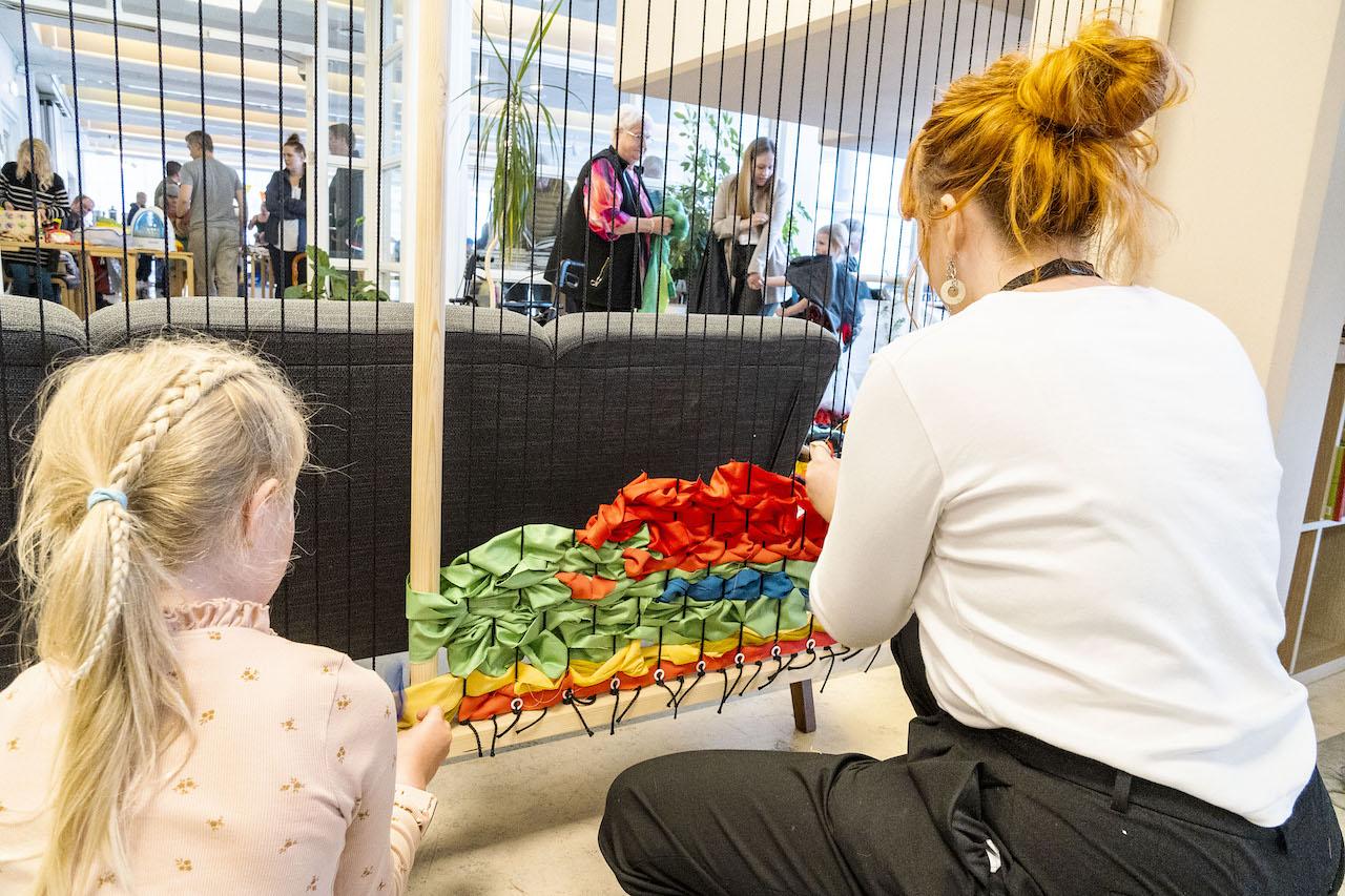 Listakonur tvær vinna veflistaverk. 
