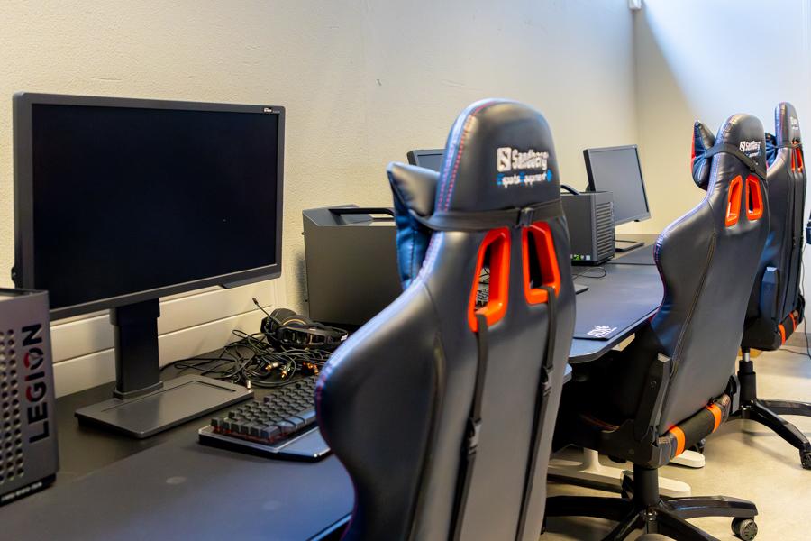 A long table with computers and office chairs. 