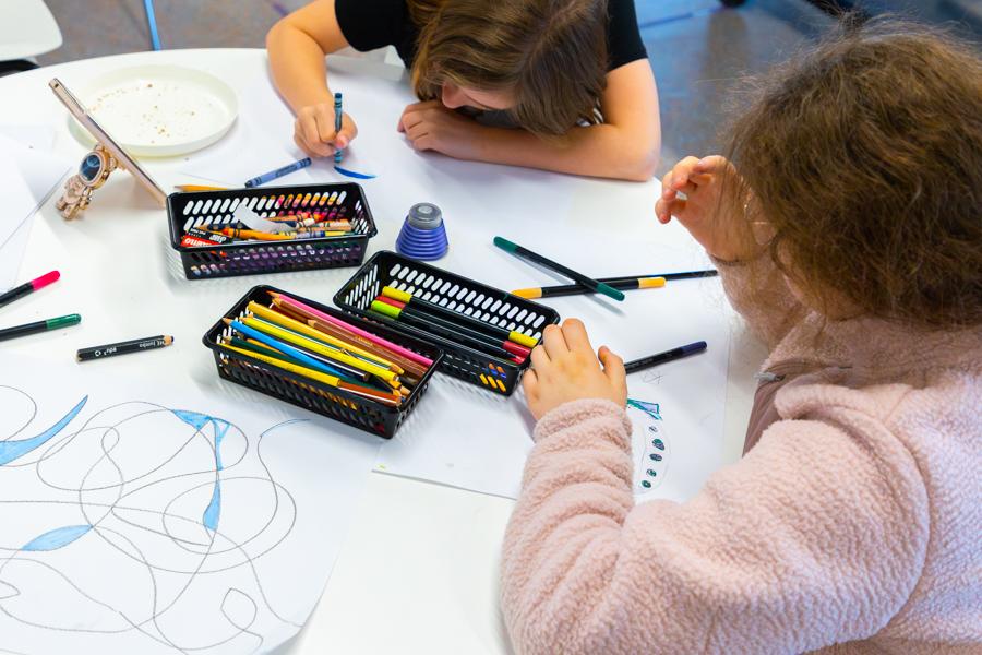 Children sit at a table coloring.