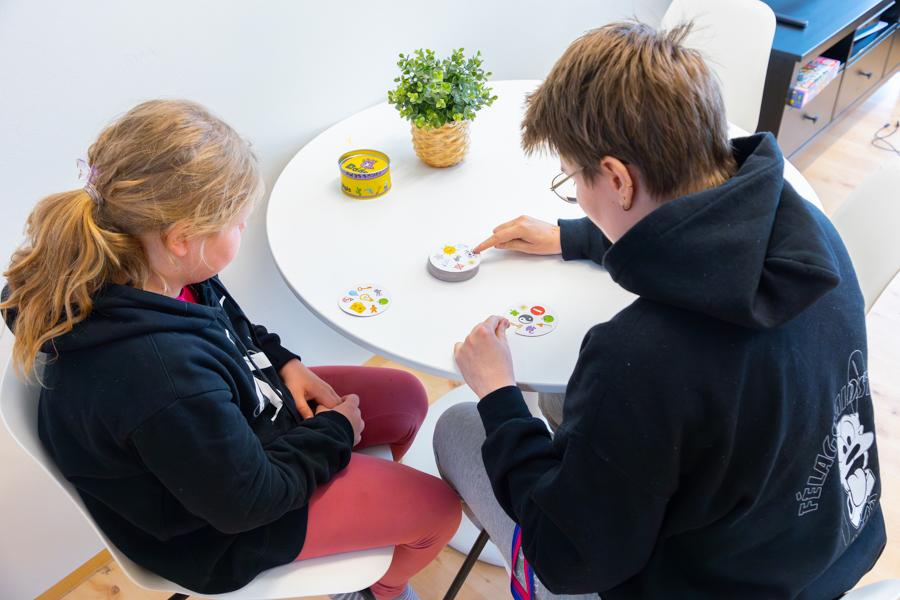 Children sit at a table playing. 