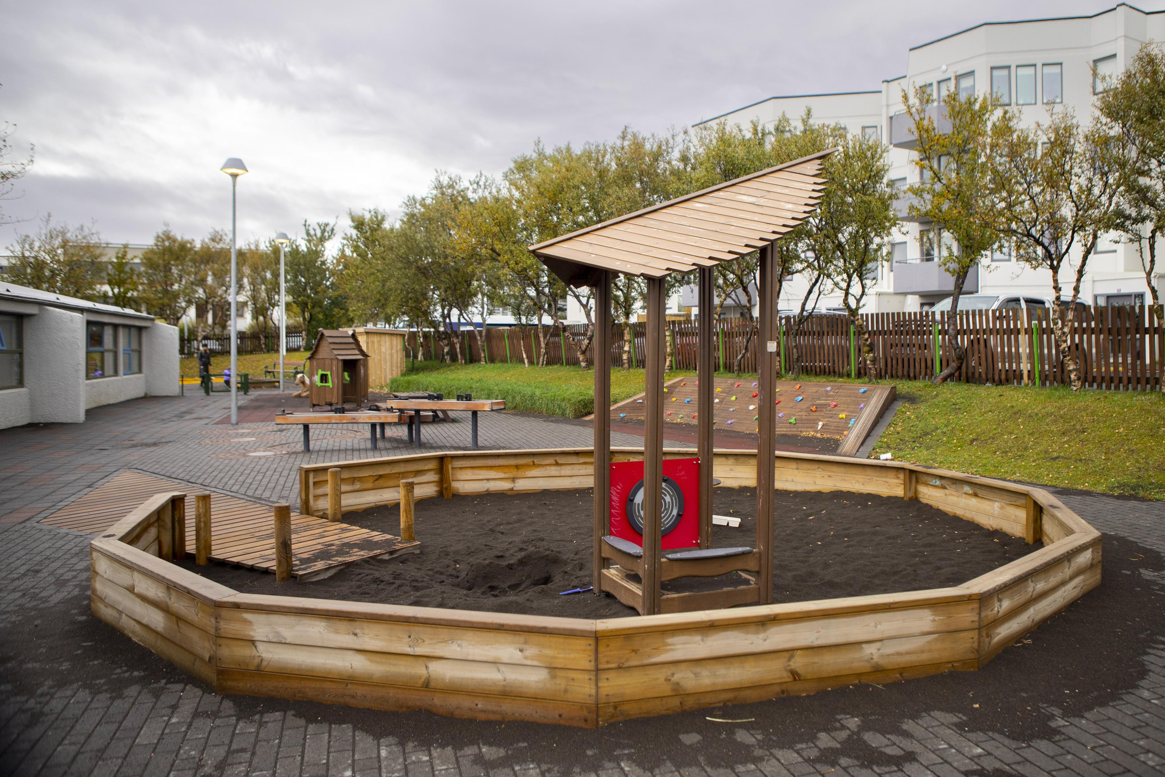 Sandbox and other playground equipment in the background on Vesturborg's grounds.