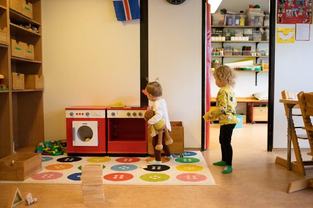 Children playing with a toy fire truck and washing machine.