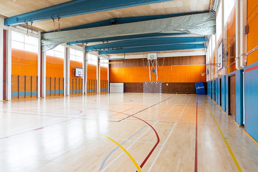 Íþróttasalur með fótboltamarki og körfuboltakörfum. 