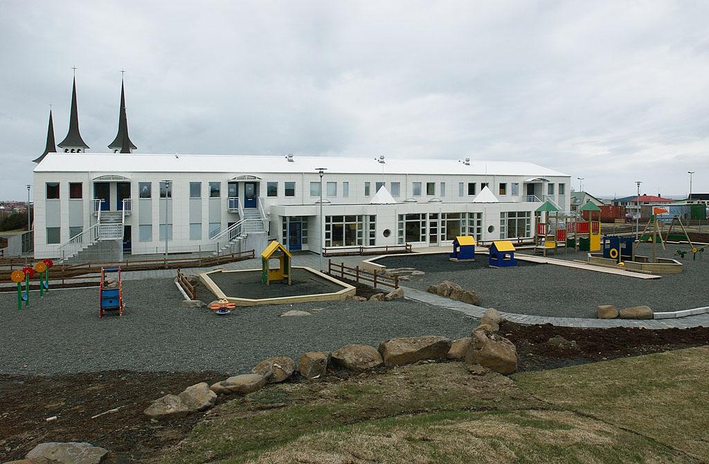 The Klambrar preschool building and its outdoor area. Háteigskirkja in the background.