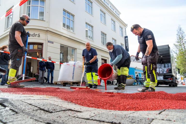 Rauð málningin borin á götuna