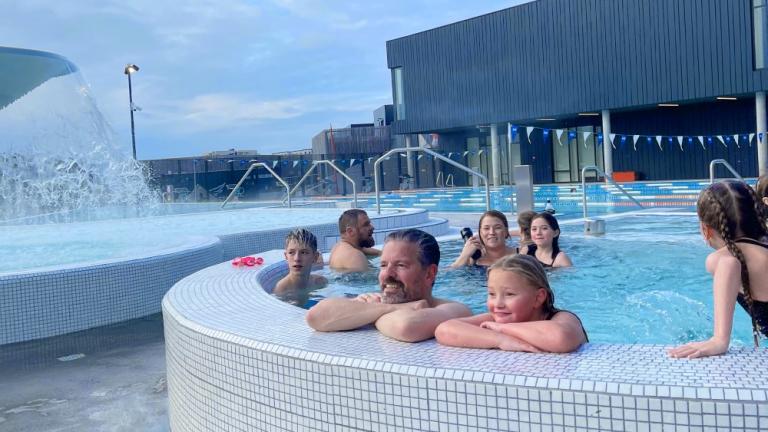 Slakað á í heita pottinum að lokinn rennibrautarferð. Með borgarstjóra á myndinni eur Eggert sonur hans og Harpa Rakel Hólm nemandi í Dalskóla.