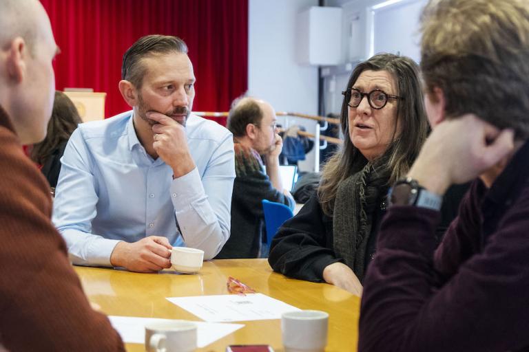 Kona sem situr við borð talar og Einar Þorsteinsson borgarstjóri hlustar