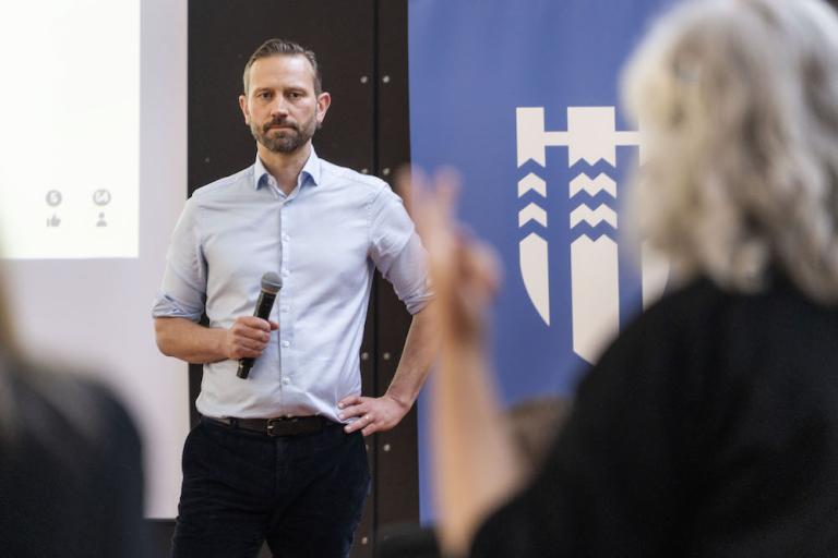 Einar Þorsteinsson borgarstjóri hlustar á konu sem sést í bak á