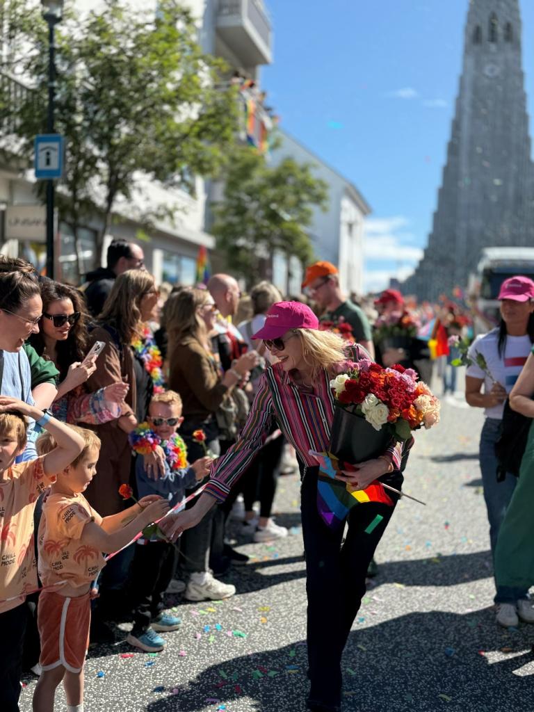 Heiða Björg Hilmisdóttir borgarstjóri að gefa rósir til gesta í Gleðigöngunni.