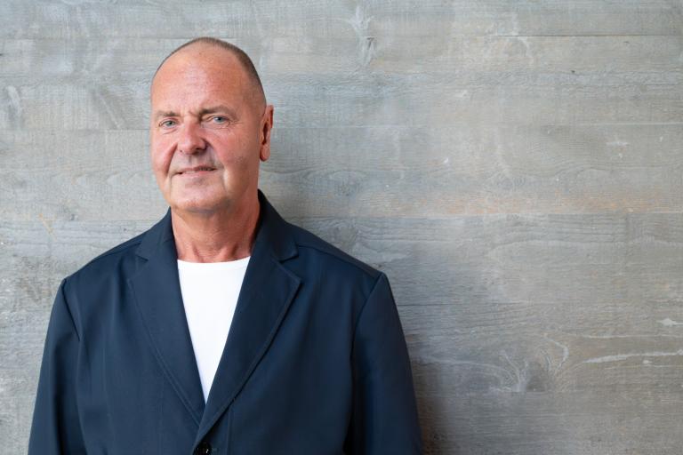 Óskar Sandholt, Director of Service & Innovation. Portrait against a gray wall.