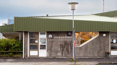 Grátt hús með grænu þaki sem hýsir leikskólann Grænuborg