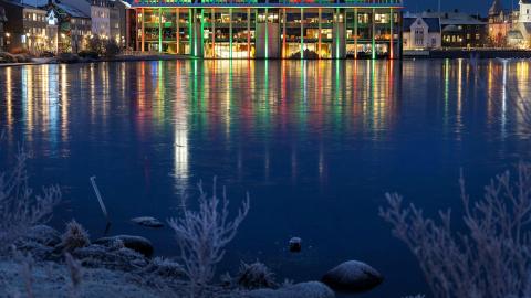 Ráðhúsið lýst með jólaljósum og frost yfir Tjörninni.