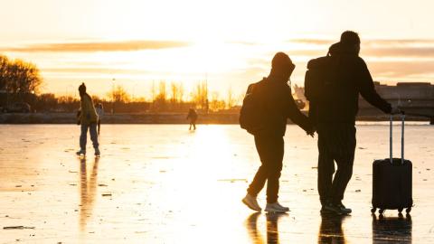 Fólk gengur yfir ísi lagða Tjörnina í Reykjavík. 