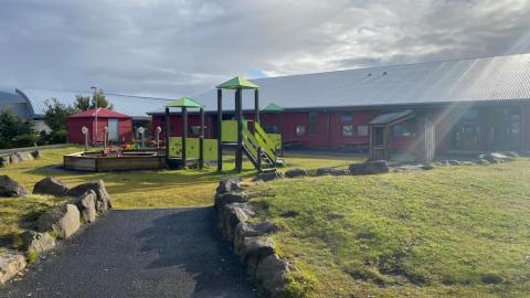 Leikkastali og lítið hús á útisvæði leikskólans Ness