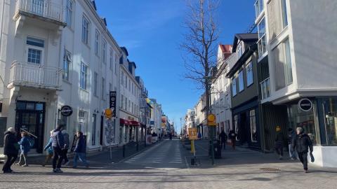 Hús, gata og fólk á gangi.