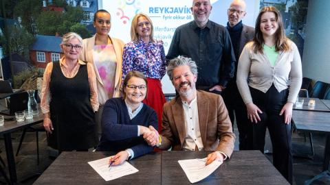 Drífa Snædal, spokesperson for Stígamót, and Mayor Dagur B. Eggertsson shake hands on the contract. Joining them are representatives from Reykjavík City's Welfare Council. 