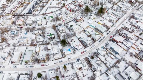 Yfirlitsmynd af Reykjavík hulinni snjó.