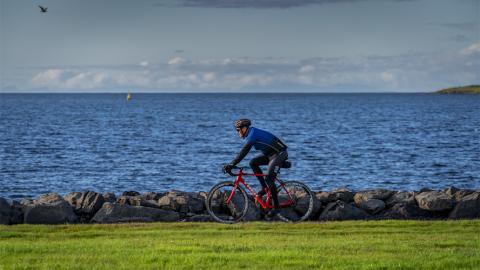 A man biking by the ocean.