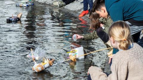 Children playing with boats at the small pond in front of City Hall