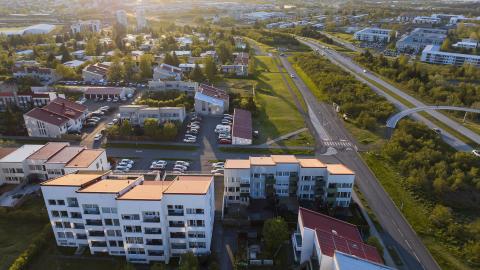 Aerial view of Breiðholt, with the city and sunset in the background