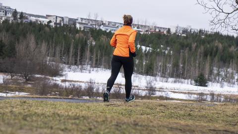 Woman running outdoors. Forest and snow.