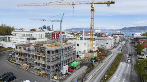 Overview of streets and buildings under construction. Large construction crane over a building.