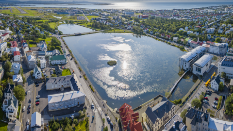 A view of Tjörnin pond and Reykjavík City Hall on a sunny day.
